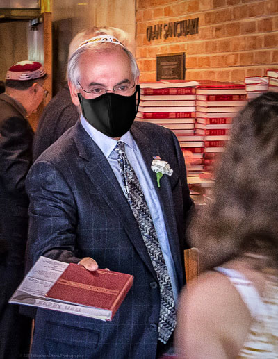 Brad Sham handing out Sidur while masked